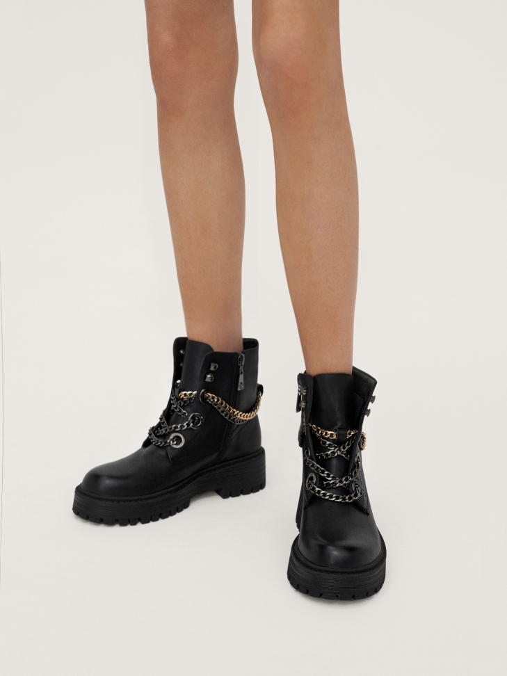 Black leather booties with chains on an elevated sole