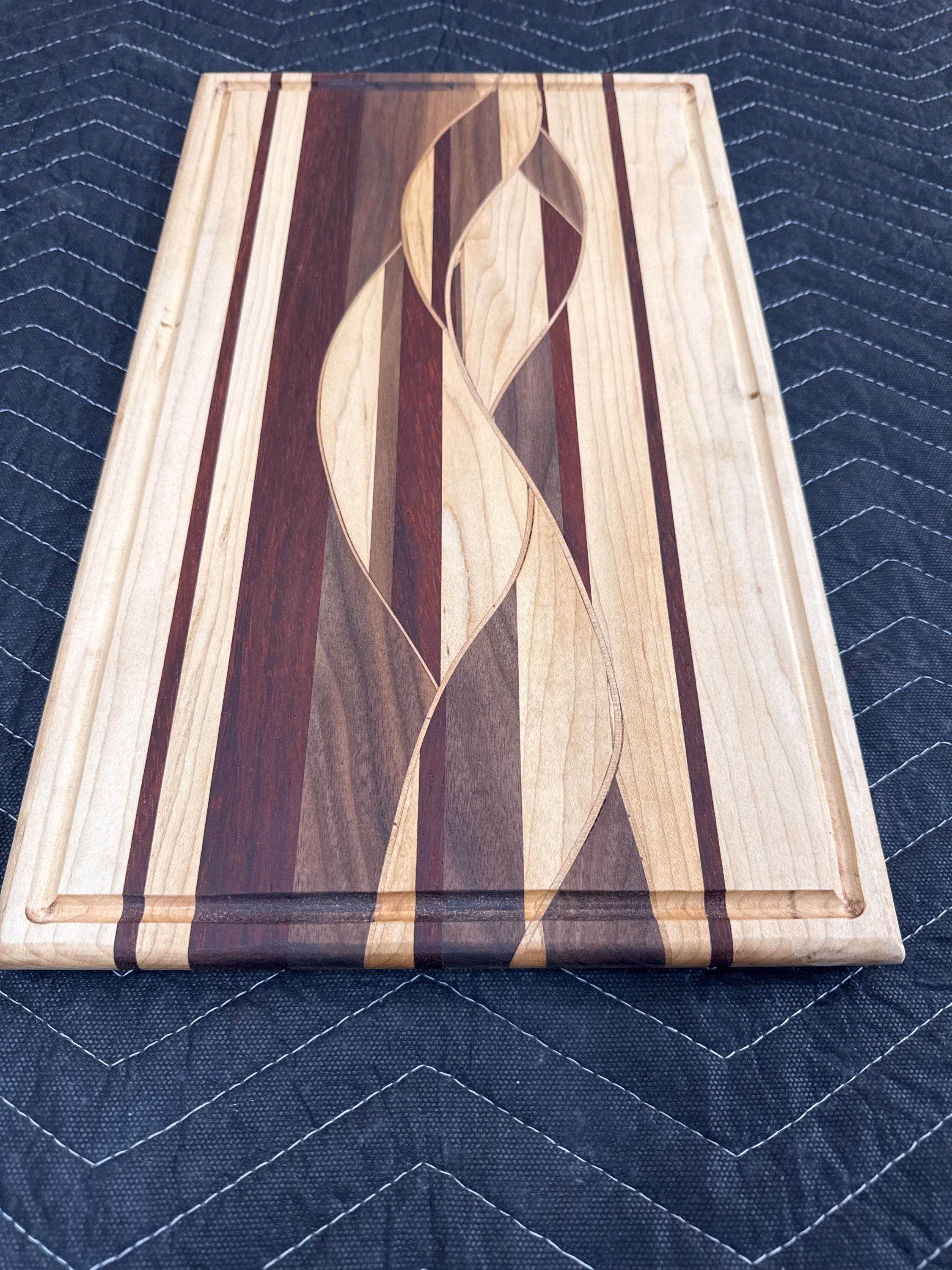 Woven wood cutting board with Maple, Walnut and Padauk.