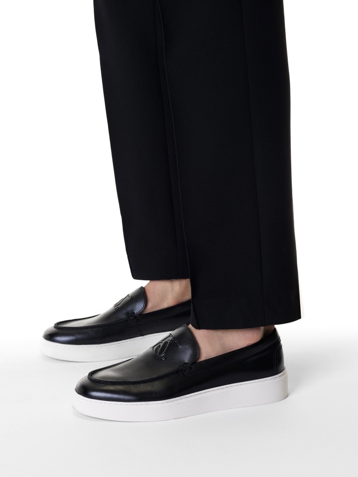 Black slip-on sneakers with white sole