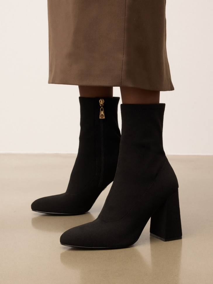 Classic black boots on a post