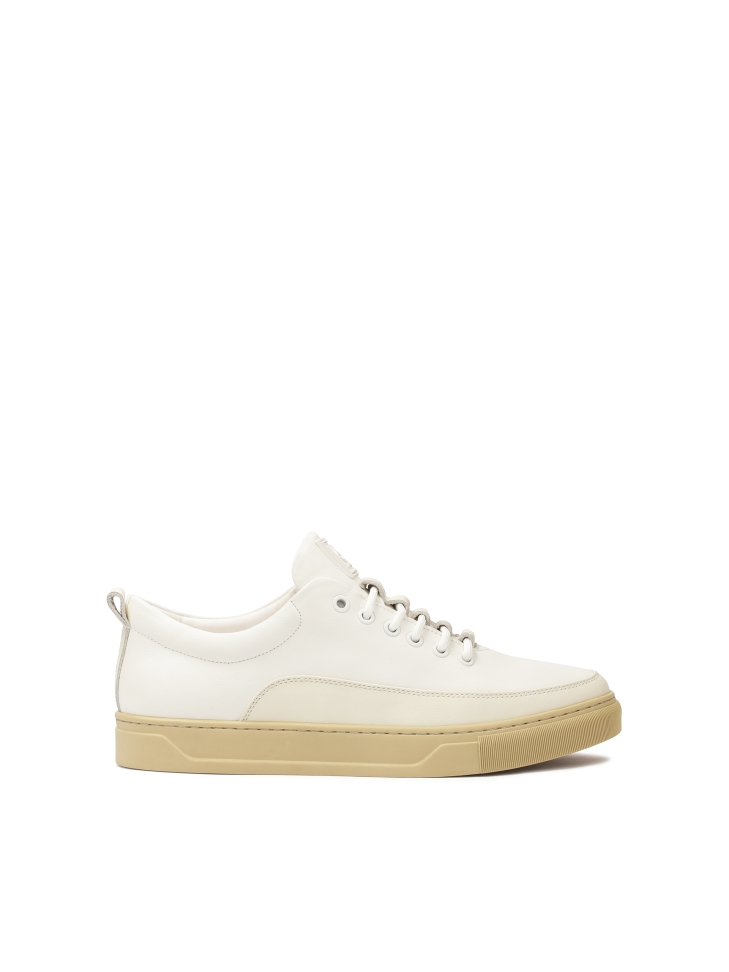 White leather sneakers on a beige sole