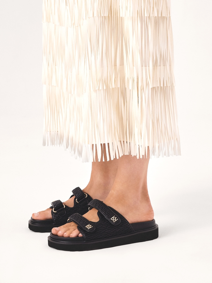 Black embossed leather slides on a comfortable sole