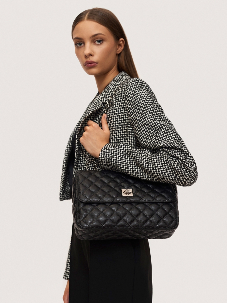 Quilted bag with a chain intertwined with a leather strap