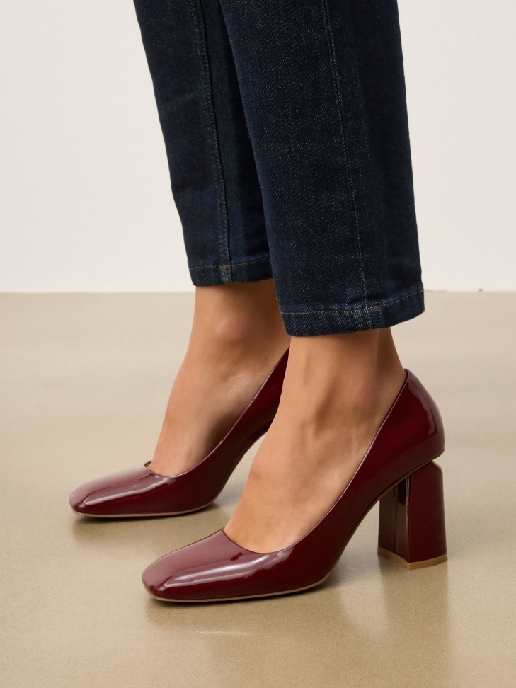 Maroon pumps with logo embellishment on the heel