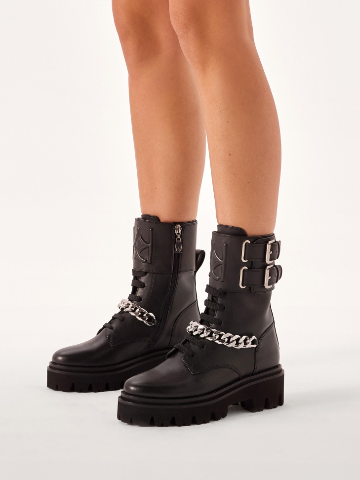 Black boots with decorative flap and chain
