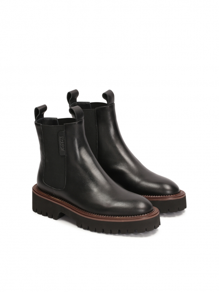 Black Chelsea boots with brown piping on the sole
