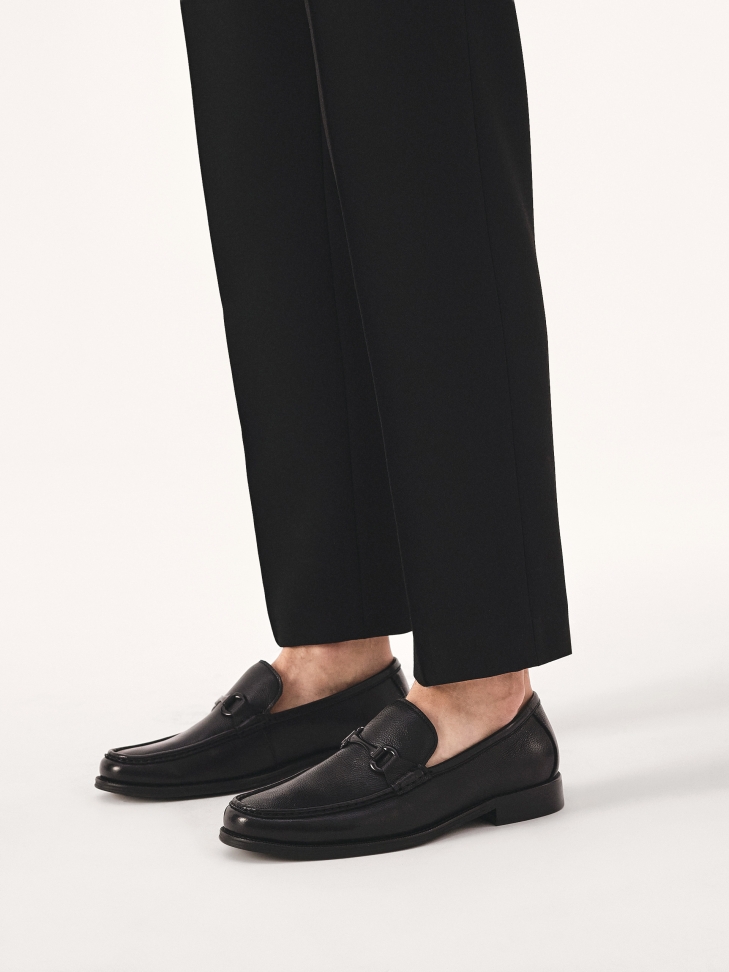 Black loafers with metal embellishment