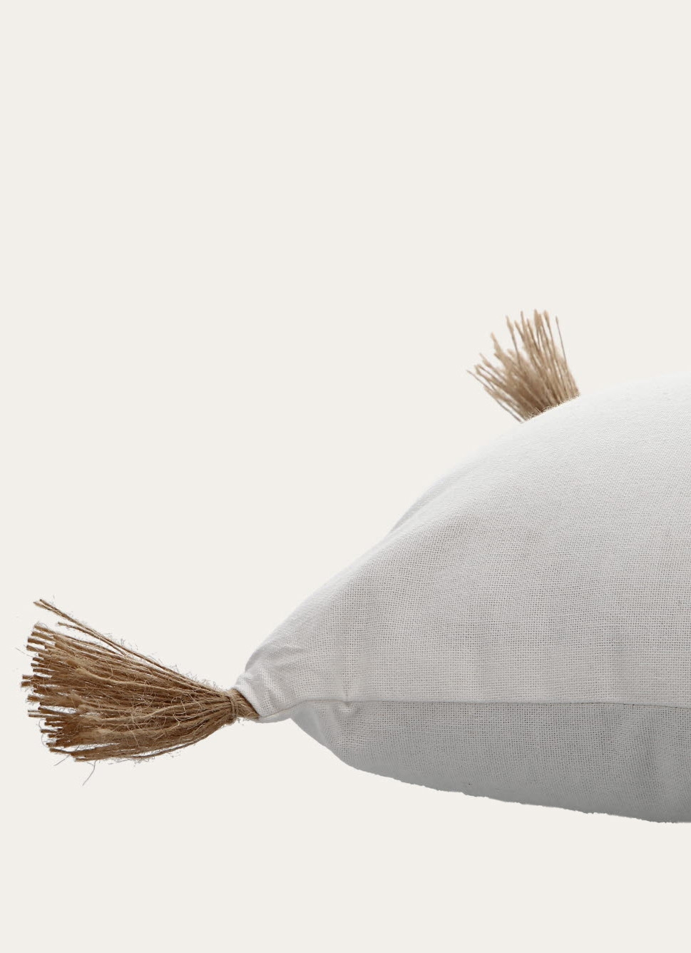 COUSSIN EN COTON UNI AVEC POMPONS EN JUTE ARGILE