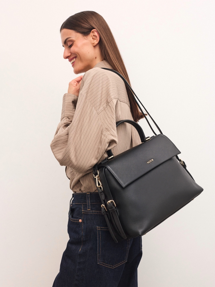 Trapeze black handbag with flap and handgrip