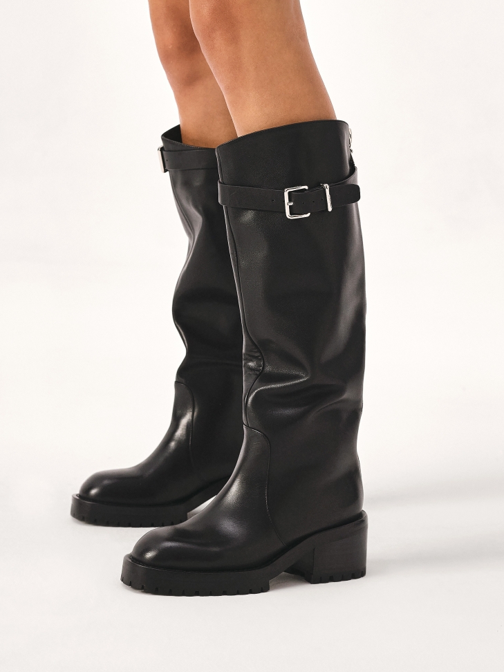 Black boots with strap and buckle around the upper