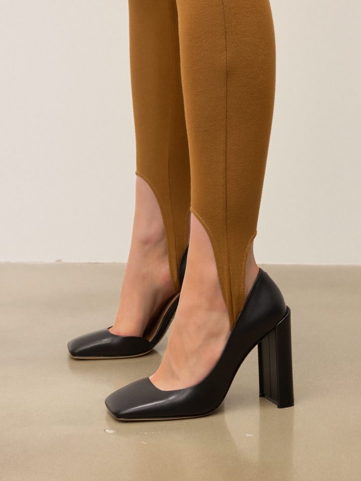 Black leather pumps on a geometric post