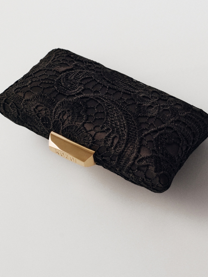 Elegant black clutch bag covered in guipure