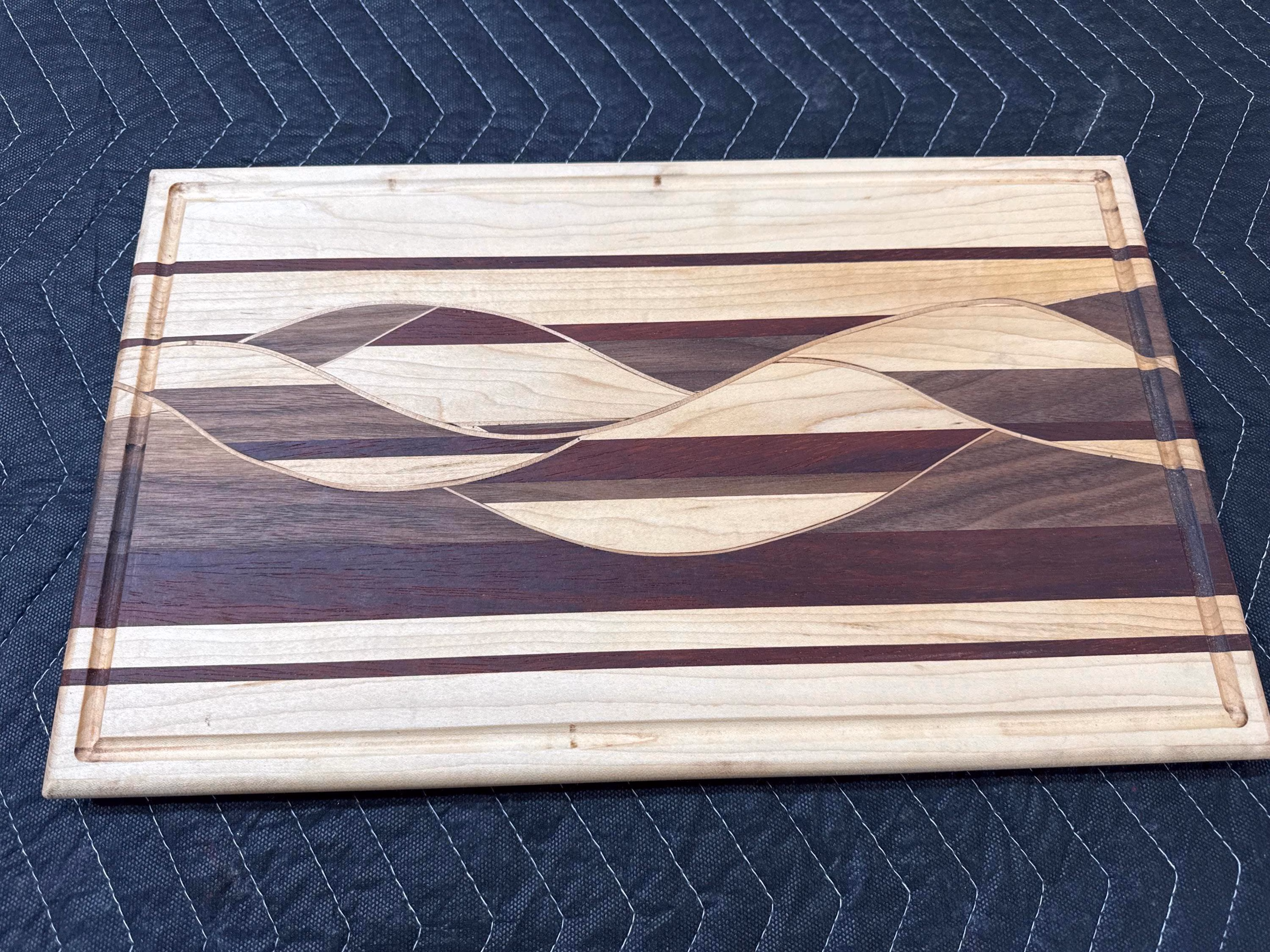 Woven wood cutting board with Maple, Walnut and Padauk.