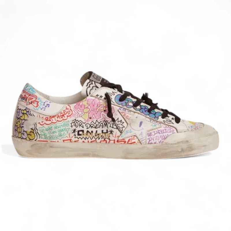 The Super-Star sneakers feature a white leather upper adorned with a vibrant multicolored graffiti print