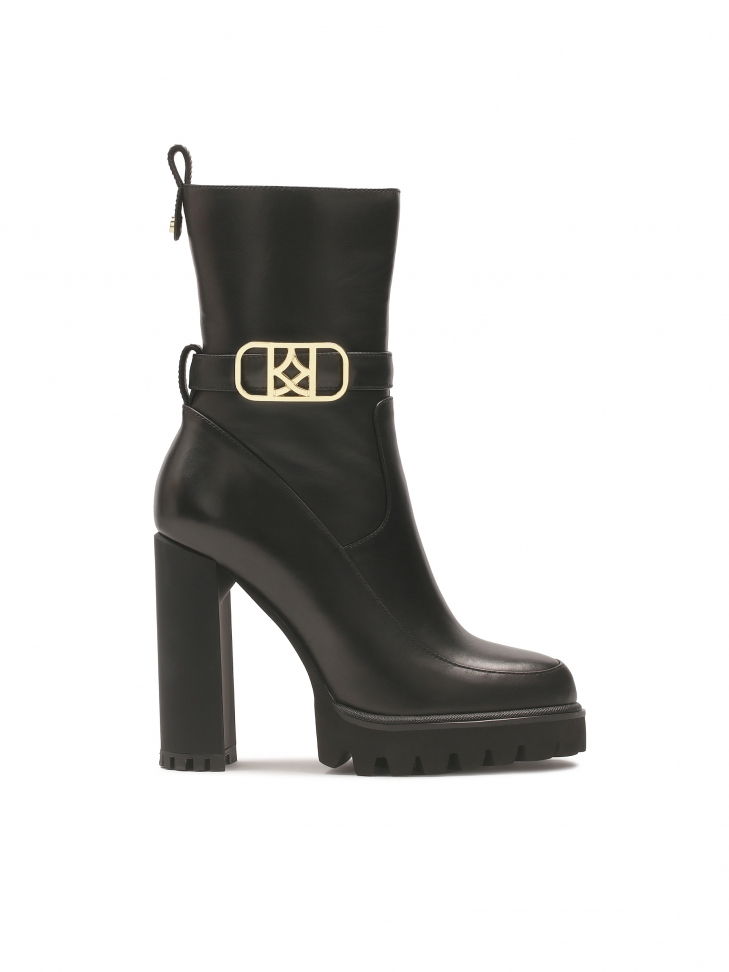 Black monogrammed KAZAR boots set on a post