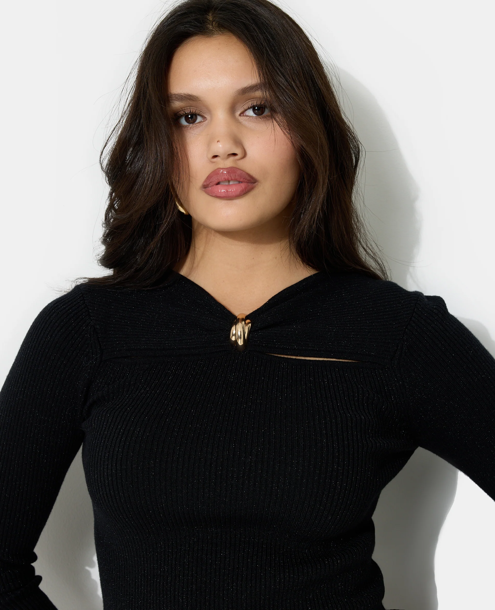 Pull cintré avec fils lurex, découpes et détail bijou