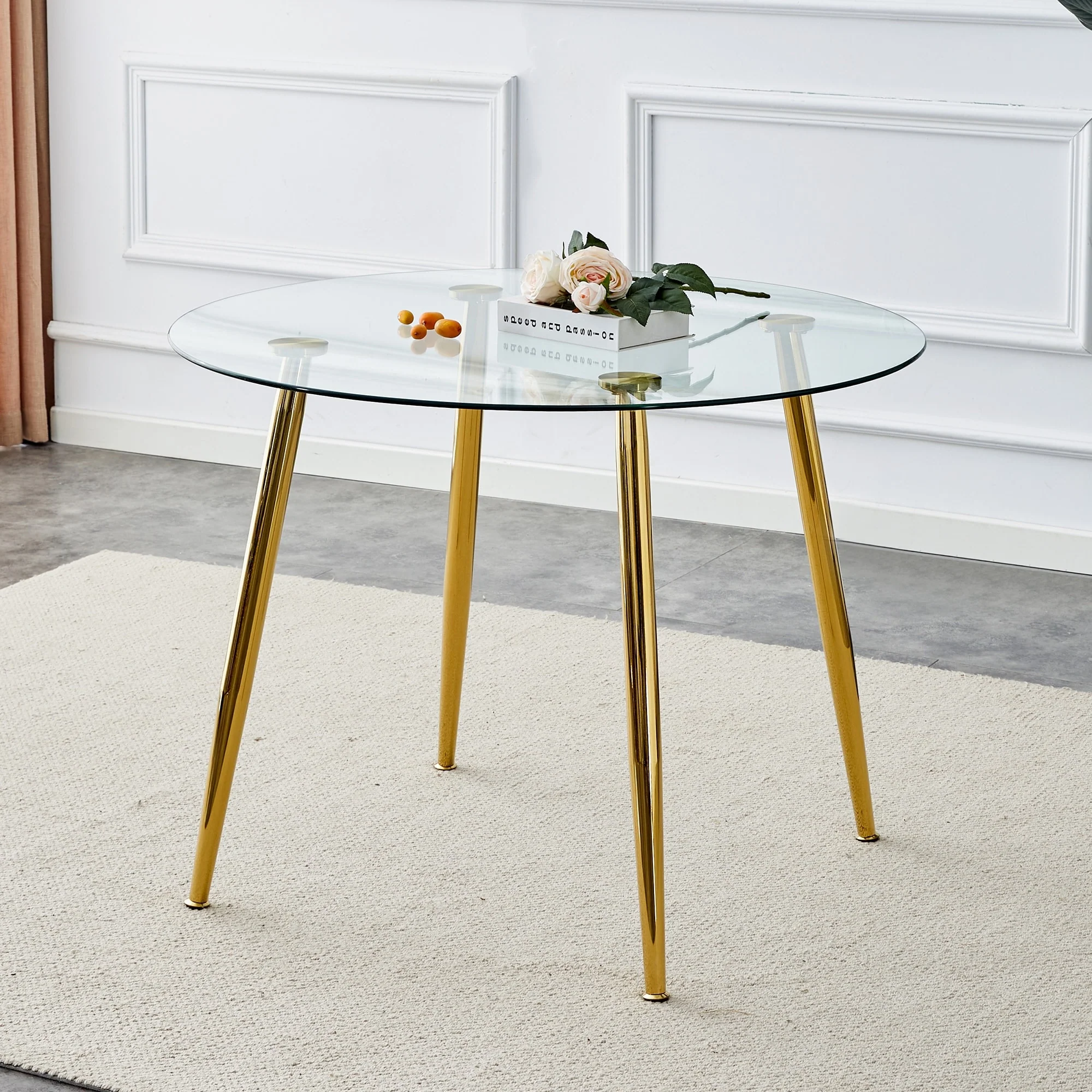 A glass tabletop with a diameter of 40 inches and a modern minimalist circular dining table with gold plated metal legs