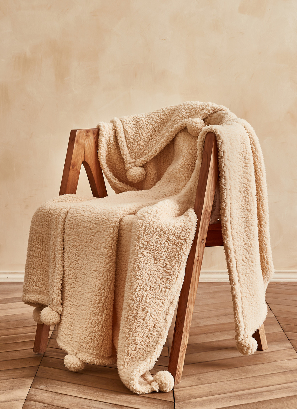 PLAID EN SHERPA AVEC FINITIONS POMPONS BEIGE