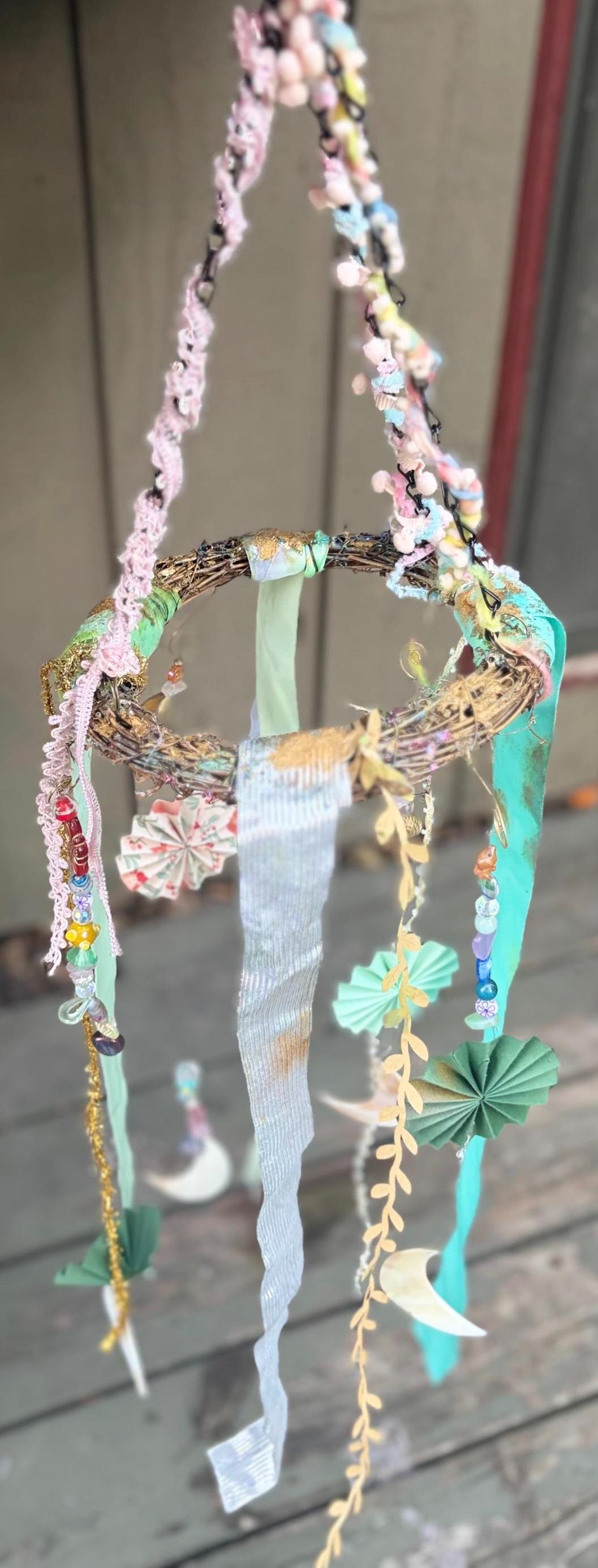 Mobile wicker wreath with ribbons, hanging pearl half moons, crystals, handmade paper pinwheels and vintage beads. Crystal wall hanging