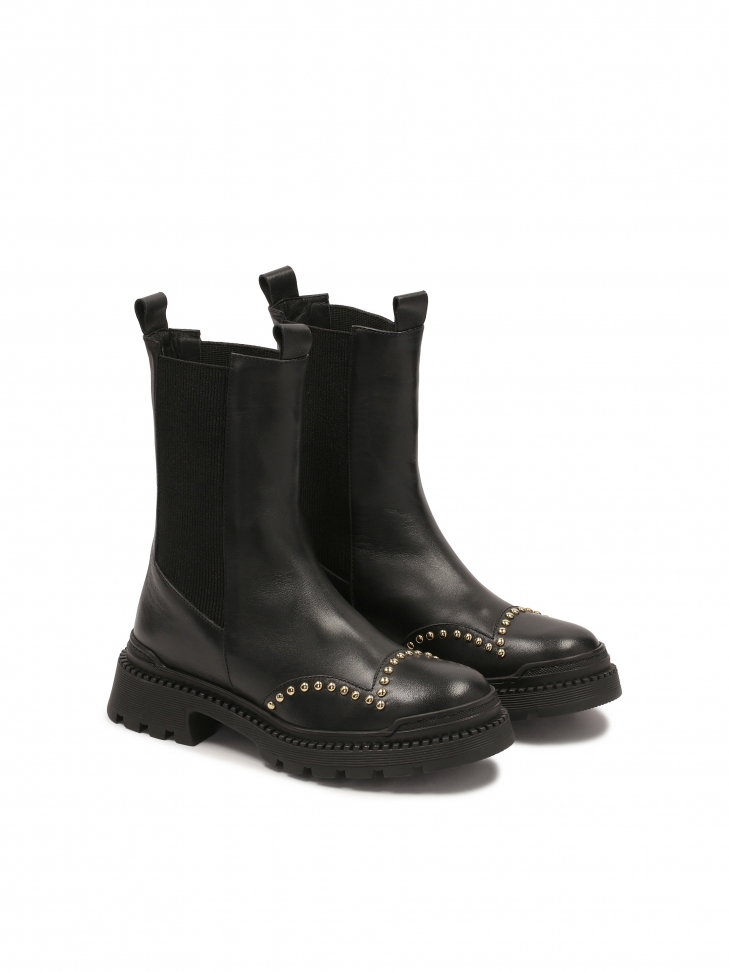 Boots with slip-on upper decorated with round rivets