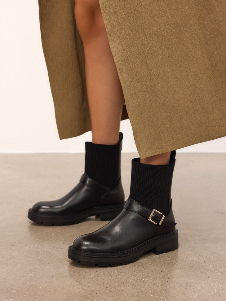 Slip-on flat boots decorated with a strap