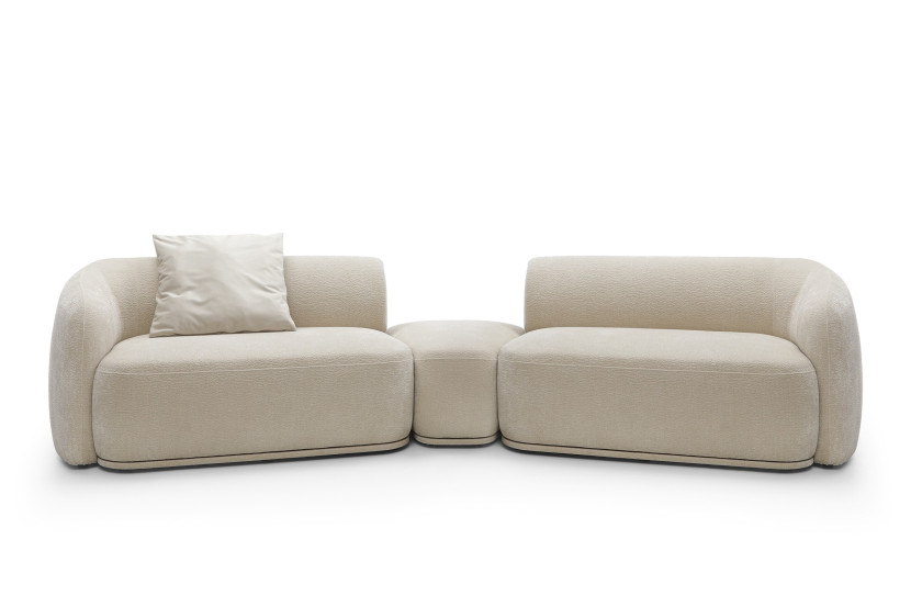 Modułowa sofa z pufą beżowa NOBIS z elegancko zaokrąglonymi bokami