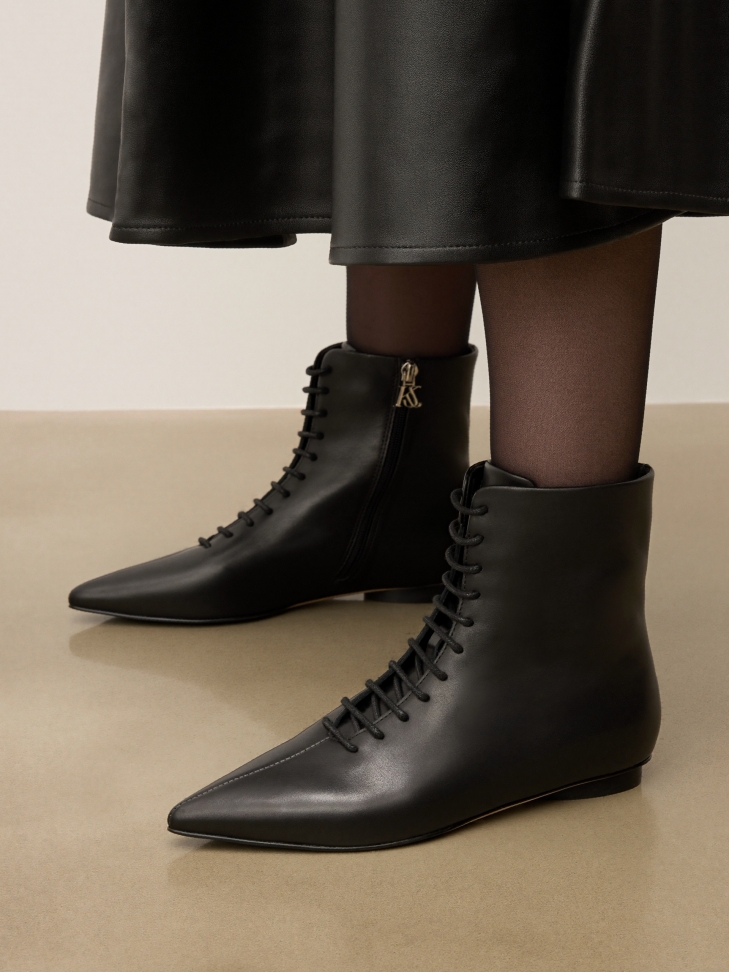 Black leather boots with zipper closure and silver logo-adorned toehold