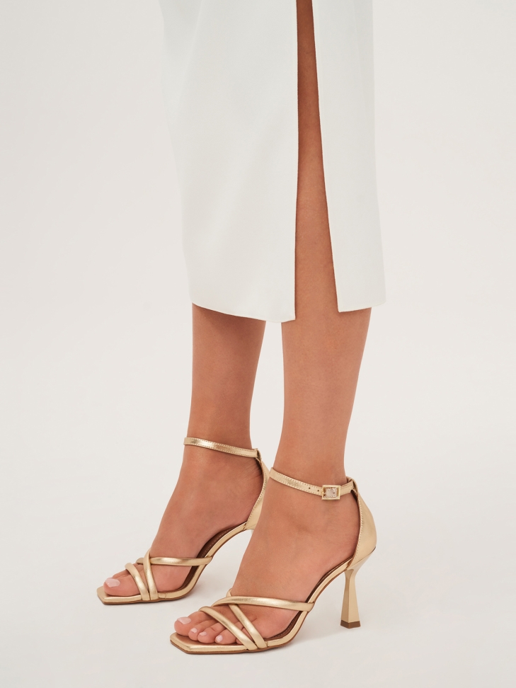 Golden sandals with a covered heel and a square toe