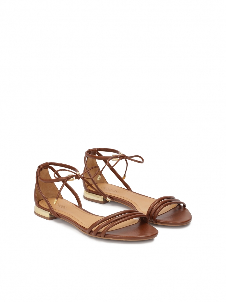 Flat brown sandals tied with a thong