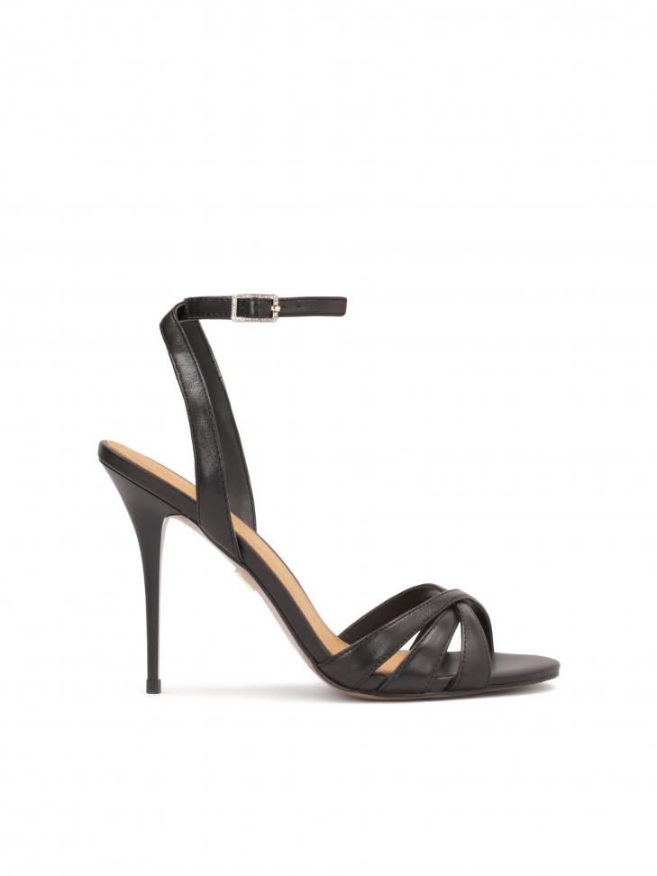 Black leather sandals fastened around the ankle