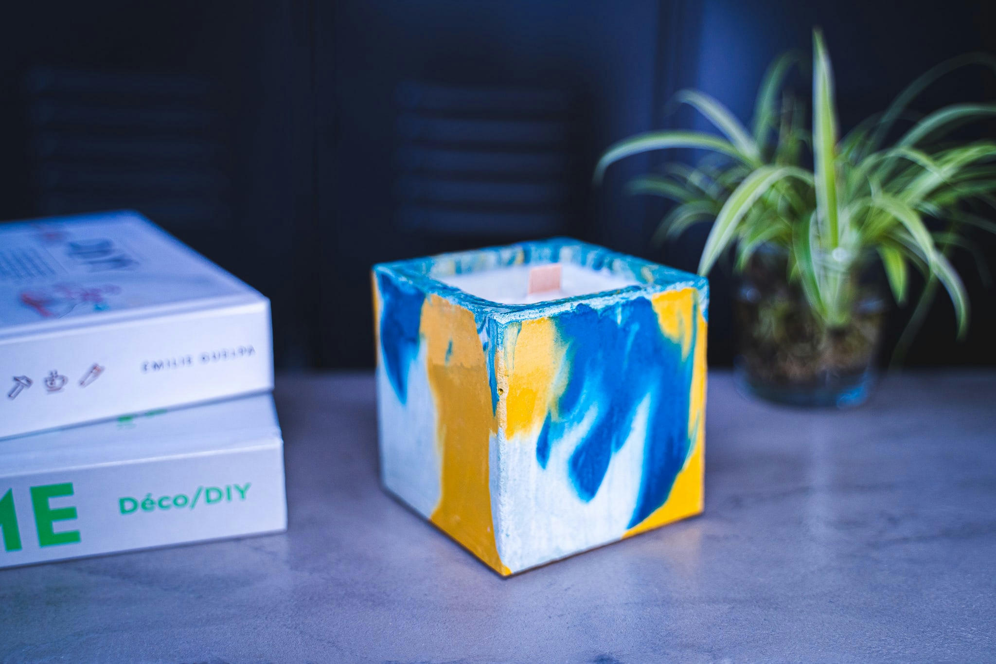 MONOÏ - Bougie en béton coloré marbré bleu et jaune fleur de monoï