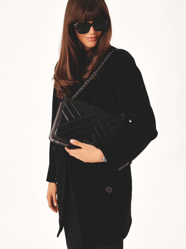 Black ornate handbag suspended from a chain