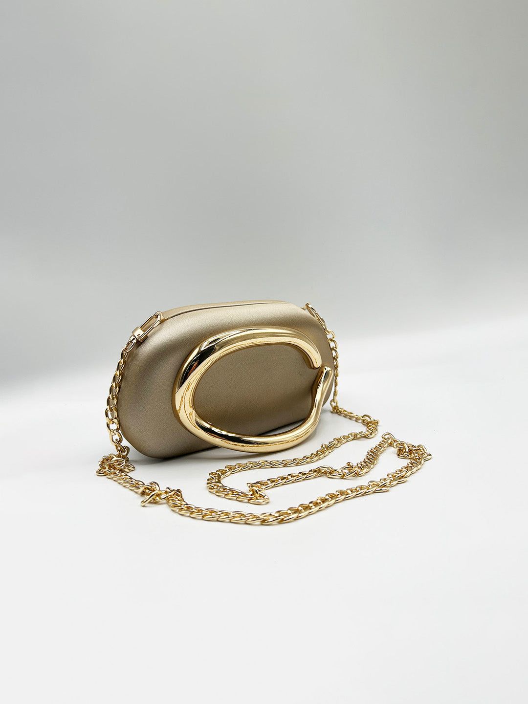 SVNX Oval Satin Hard Case Clutch Bag In Muted Gold