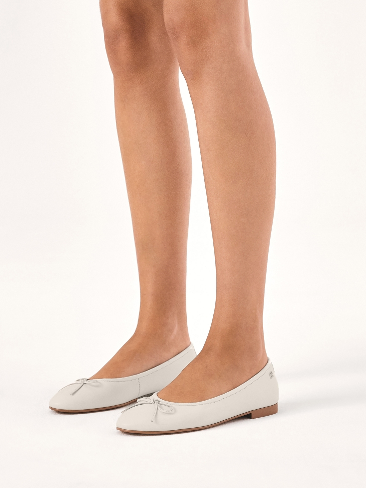 White leather ballerinas on a brown sole