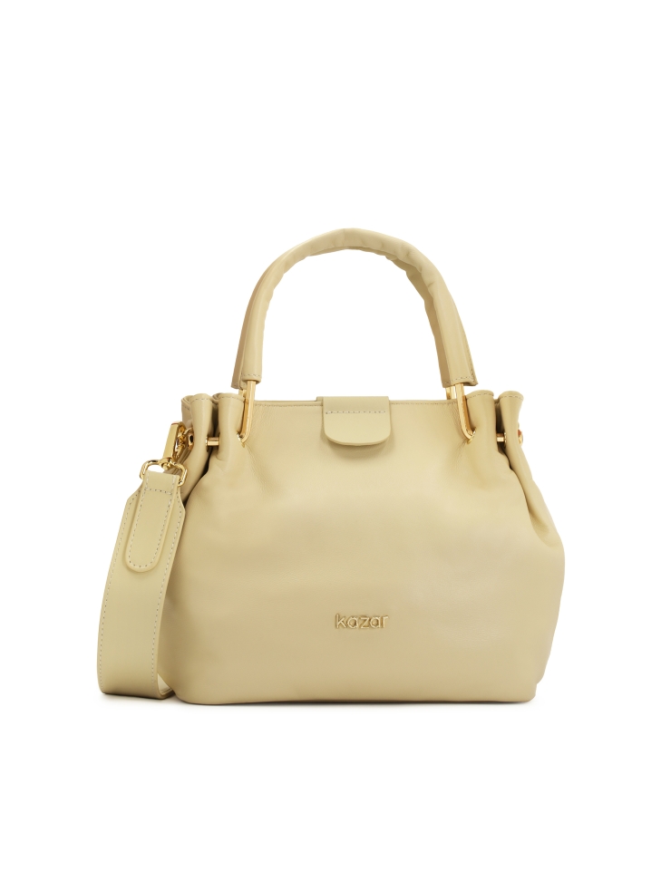 Elegant cream handbag with a crease at the handles