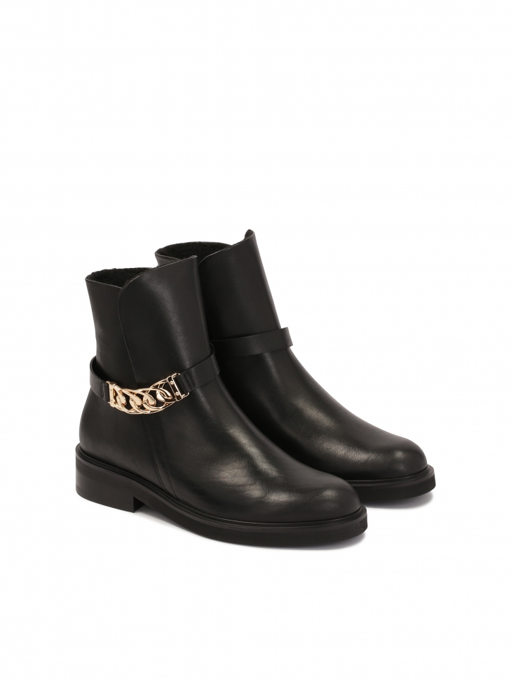Classic boots on a flat sole decorated with a chain