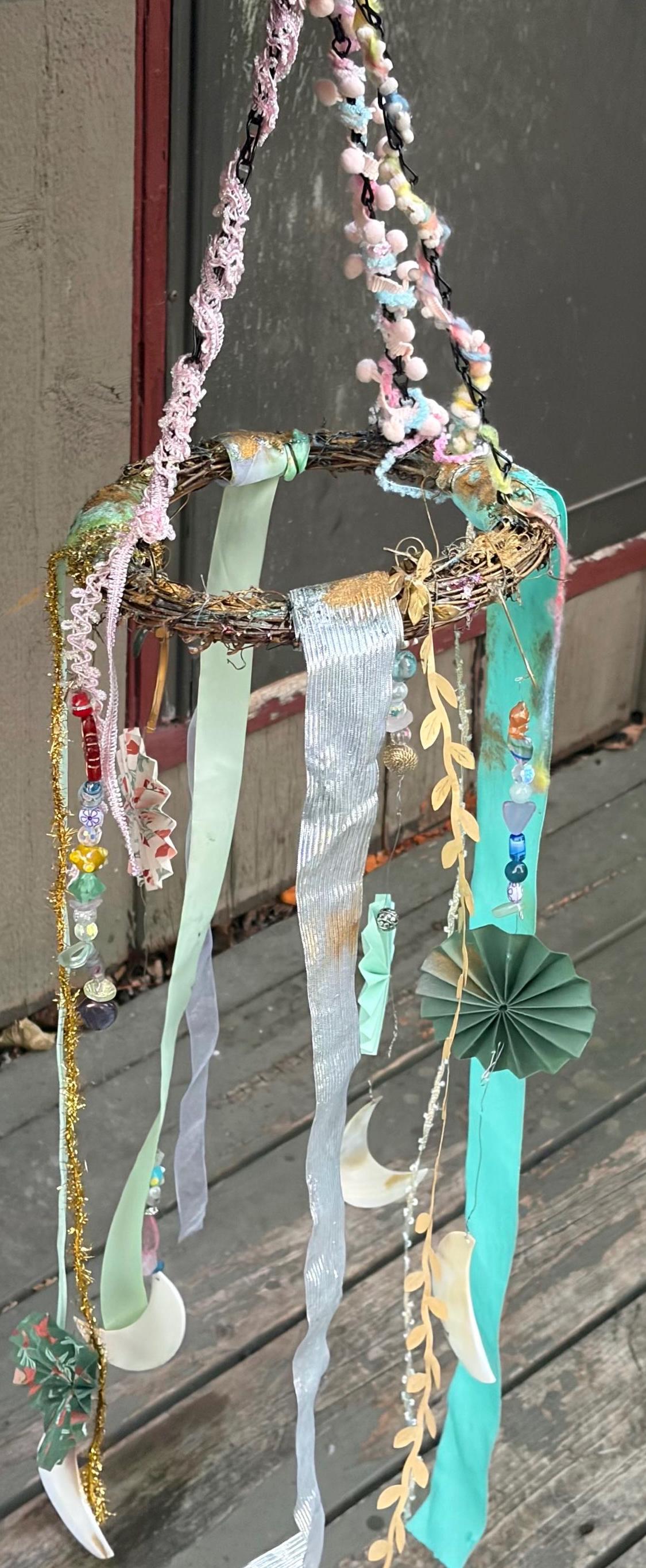 Mobile wicker wreath with ribbons, hanging pearl half moons, crystals, handmade paper pinwheels and vintage beads. Crystal wall hanging