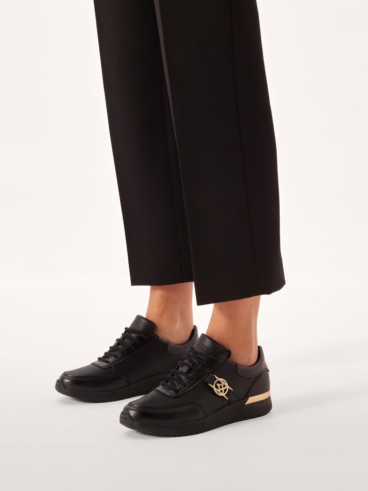Black leather sneakers decorated with gold elements