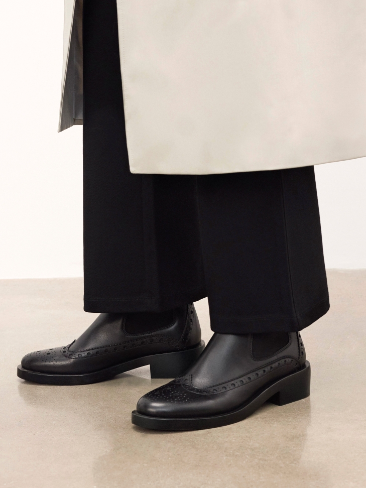 Black Chelsea boots with rosette embellishment
