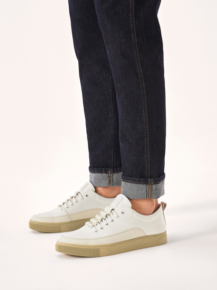 White leather sneakers on a beige sole