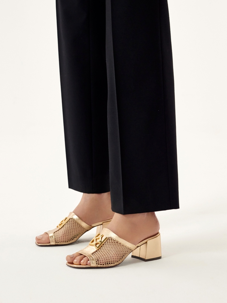 Openwork gold mules decorated with a monogram