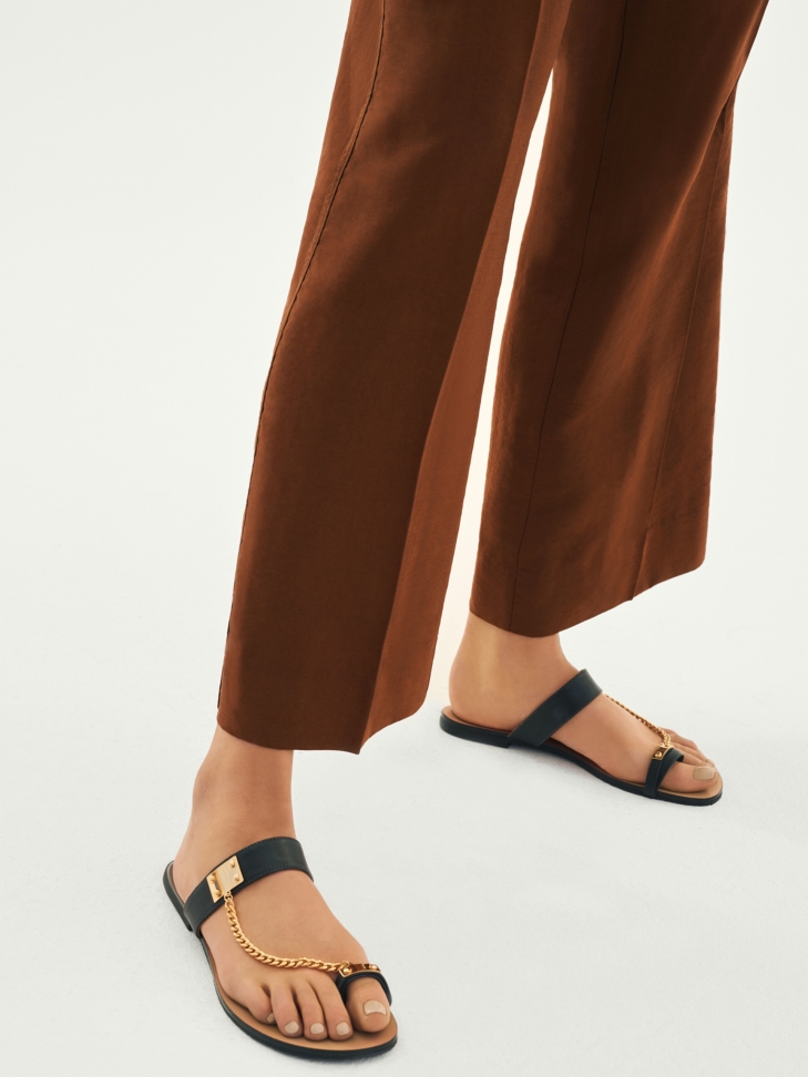 Black leather slides with decorative chain detailing