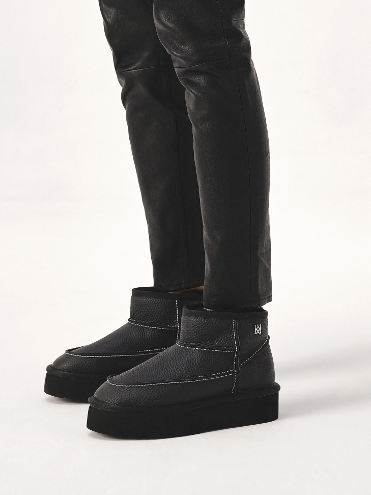 Black leather snow boots with white threading