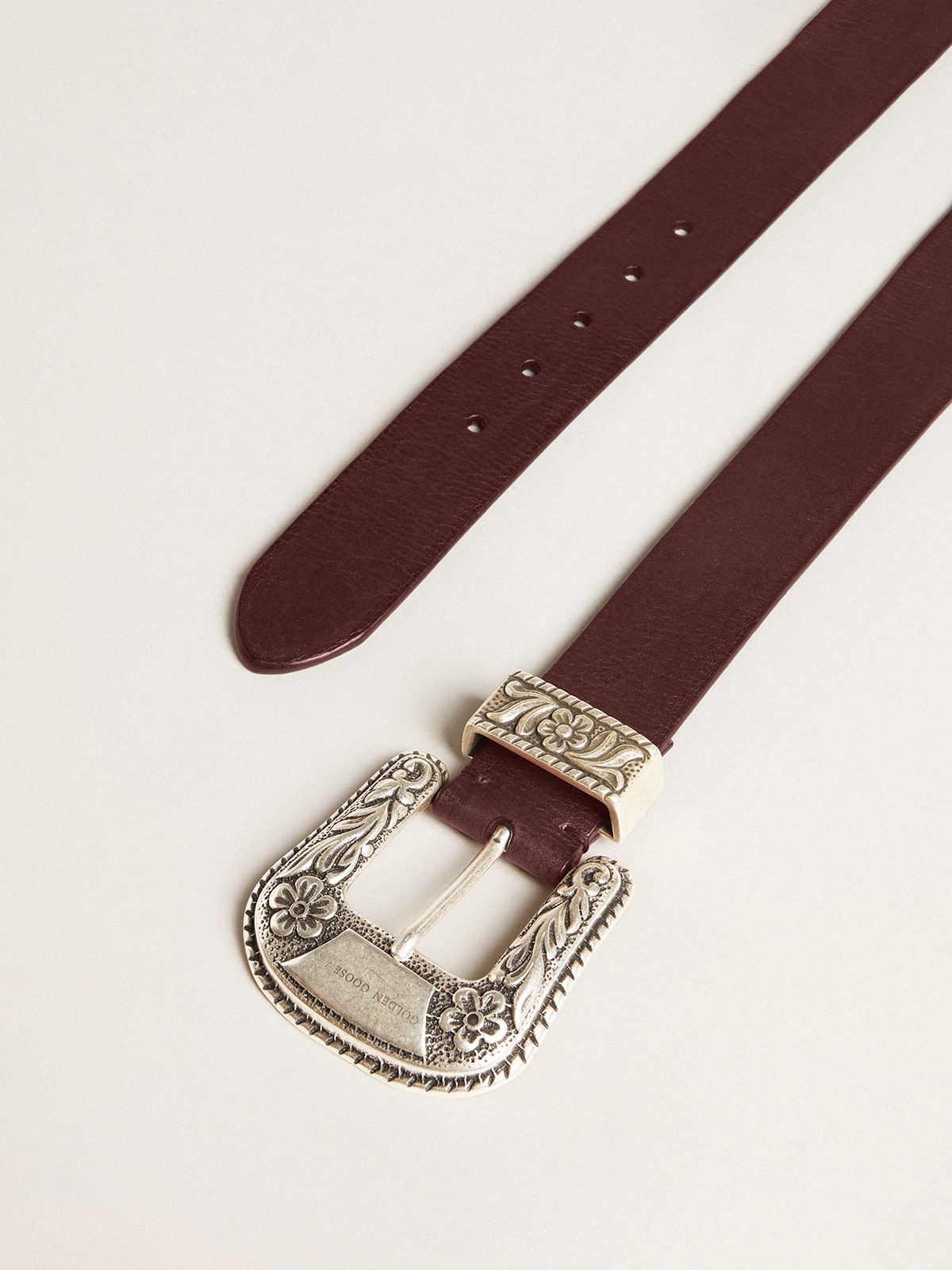 Women's belt in burgundy leather with decorated silver buckle