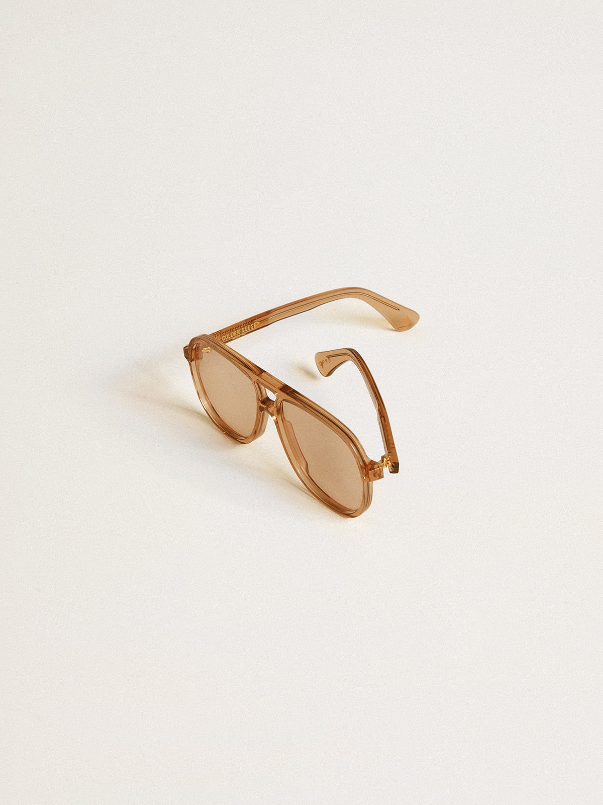 Aviator style sunglasses with honey-colored frame and lenses