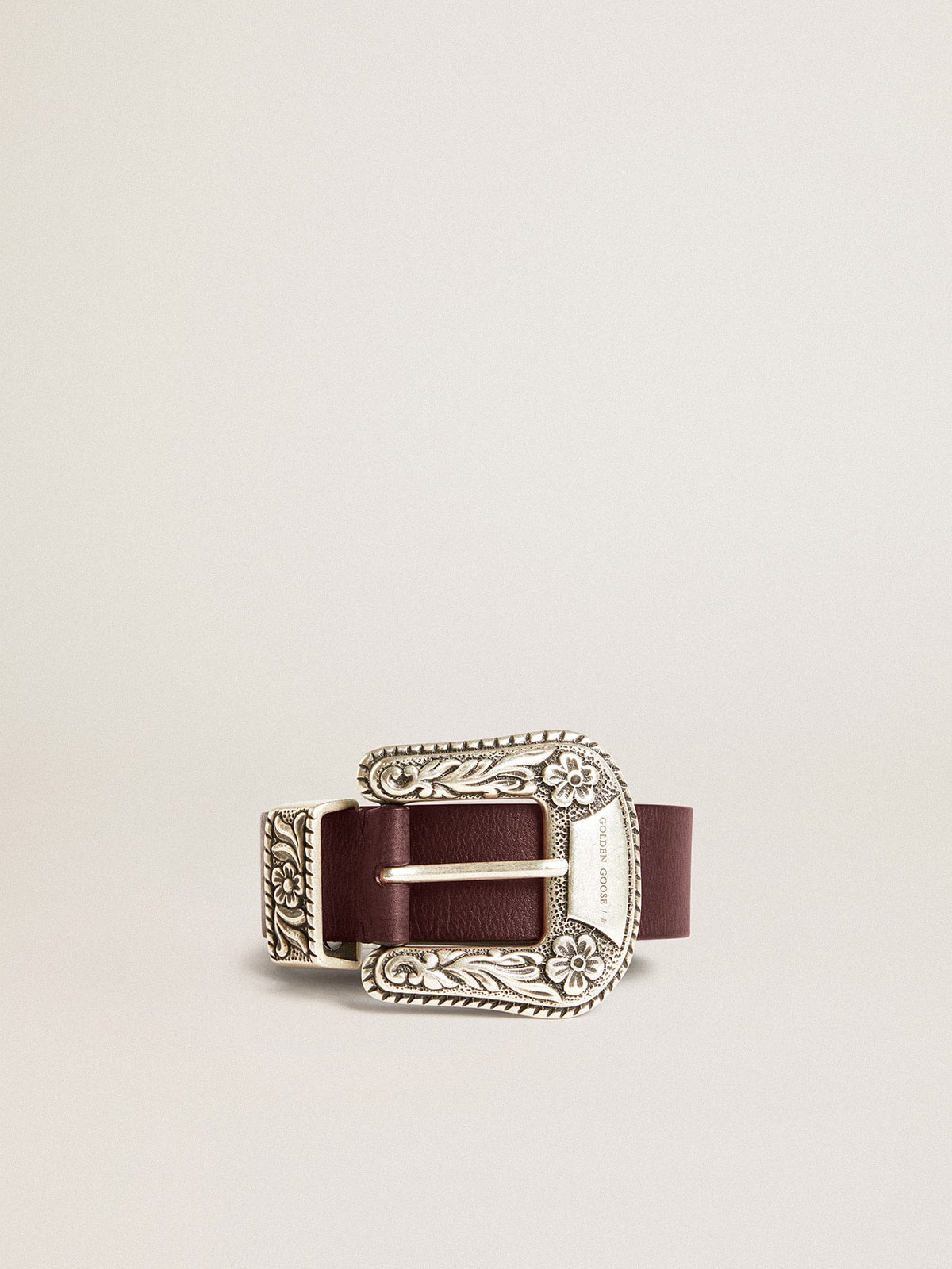 Women's belt in burgundy leather with decorated silver buckle