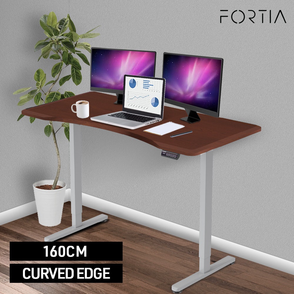 FORTIA Sit To Stand Up Standing Desk, 160x75cm, 72-118cm Electric Height Adjustable, Ergonomically Curved Edge, 50kg Rated, Walnut Style/Silver Frame