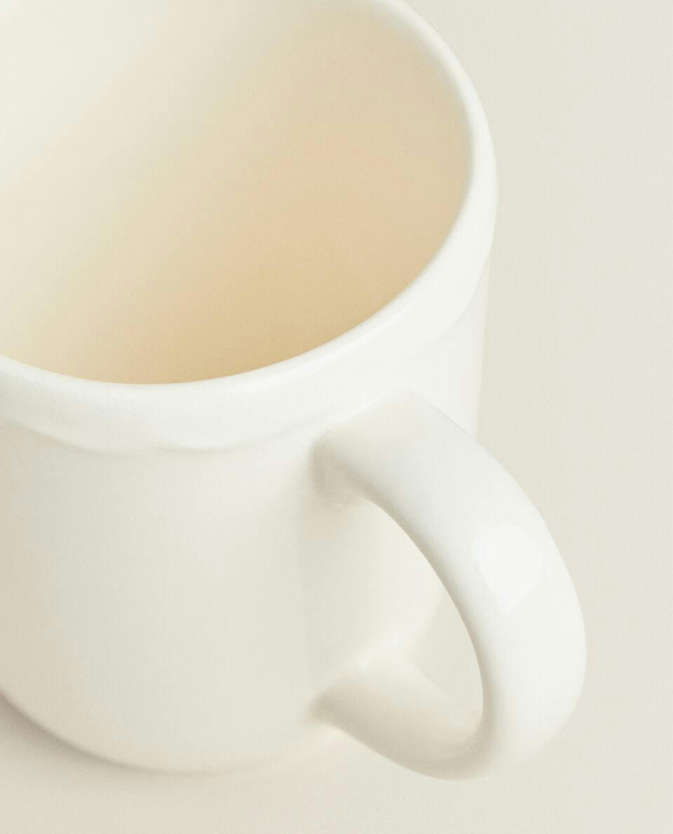 EARTHENWARE MUG WITH A RAISED-DESIGN EDGE