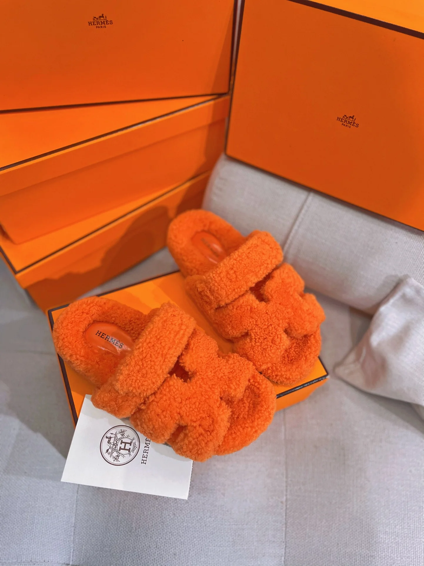 Новинка осенне-зимней коллекции Hermes 2022 — тапочки H из овечьей шерсти и кожи в стиле пэчворк — оранжевые.