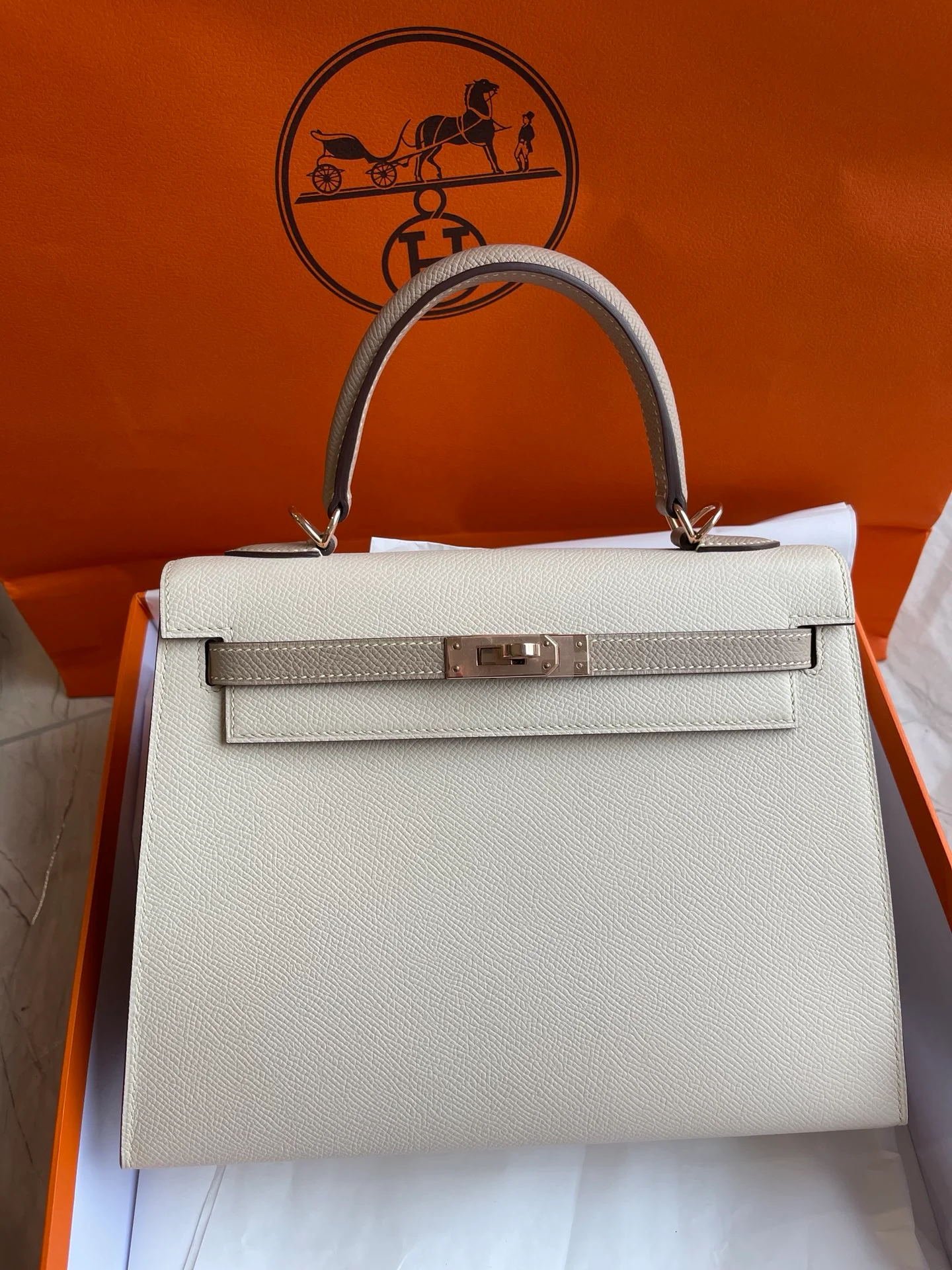 Hermes Kelly 25 Epsom Milkshake White с серым тренчем и пряжками из розового золота.